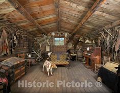 a living room filled with lots of wooden furniture and animals on the wall behind it