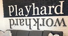 a gray couch sitting in front of a sign that says play hard perplexon