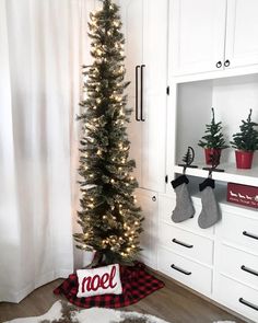 a christmas tree with stockings hanging from it's sides in a room decorated for the holidays