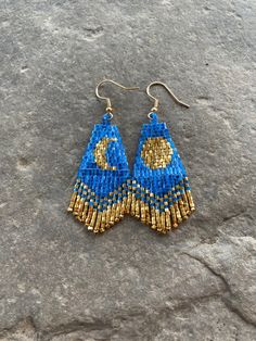 *Crescent and Full Moon short fringe earring. These beautiful statement earrings are made with gratitude and mindfulness. Wear these magical earrings and connect with the energy of the moon.  *Made with 11/0 Miyuki Delica Seed Beads in colors of Electric Blue and 24 Karat Gold and finished with high quality .925 Gold Ear Wire  *They measure just two and a half inches in length including Ear Wire and just under one inch in width  *These earrings are designed and handmade with so much love and may not be copied without my permission *5% of all sales goes towards supporting Native American communities Native American Beadwork Earrings Moon & Milk, Crescent Moon Beaded Earrings, Moon Fringe Earrings, Bohemian Blue Moon Shaped Earrings, Bohemian Blue Moon-shaped Earrings, Magical Earrings, Fringe Earring, Short Fringe, Seed Bead Patterns