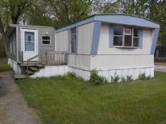 an old mobile home sits in the grass