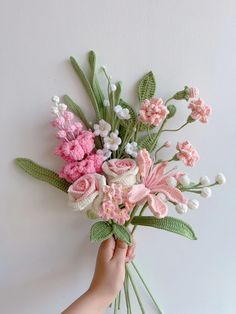 someone is holding a bouquet of flowers on the wall