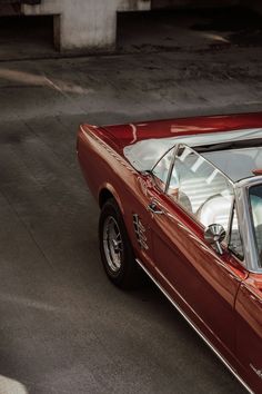 an old red car is parked on the street