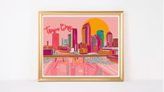 a framed photograph of a cityscape in pink and yellow