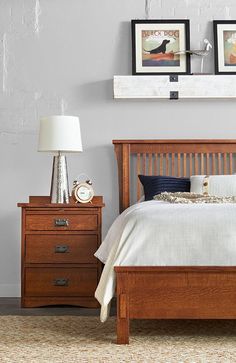 a bedroom with a bed, nightstands and two pictures on the wall above it