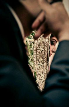 a close up of a person holding a piece of jewelry in front of their face