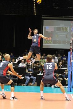 some men are playing volleyball on a court