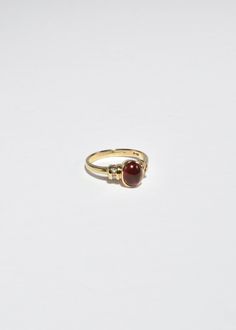 Beautiful vintage gold ring with a polished ruby cabochon and diamond detail. Stamped 10k. Material: 10k gold, ruby, diamond. We recommend storing in a dry place and periodic polishing with a cloth.