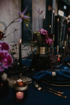 the table is set with purple flowers and candles