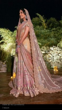 a woman in a bridal gown standing on a wooden platform with her veil draped over her head