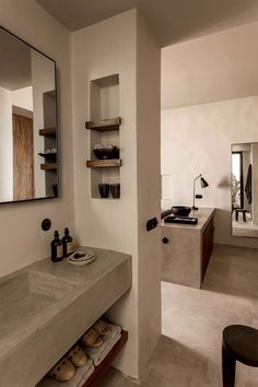 a bathroom with a sink, mirror and shelves