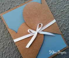 a blue and brown card with a white ribbon