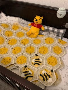 a winnie the pooh crocheted blanket on top of a bed with honeybees