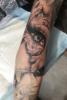 a person with a tattoo on their arm that has an eye in the middle and two lions