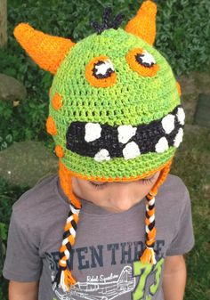 a young boy wearing a crocheted monster hat