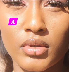 a close up of a woman's face with a pink sticker on her nose