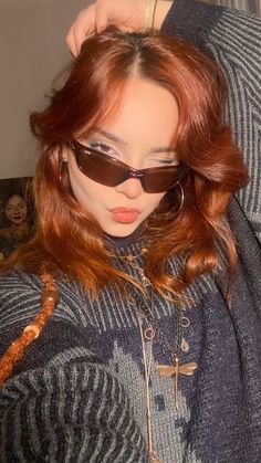 a woman with red hair wearing sunglasses