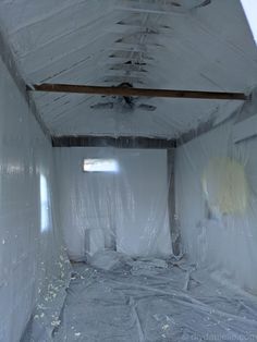 an unfinished room with white plastic covering the walls and ceiling, while it is being renovated