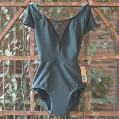 a women's bodysuit hanging on a wooden fence