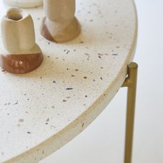 two ceramic vases sitting on top of a white table next to each other,