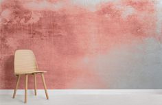 a wooden chair against a pink and grey wall