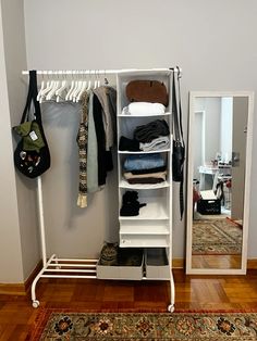 a white closet with clothes and shoes on it