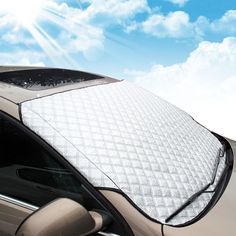 a car with a snowboard on the roof is parked in front of a blue sky