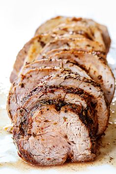 sliced meat sitting on top of a white plate