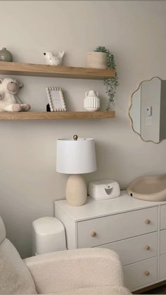 a white room with two shelves and a mirror on the wall, one shelf is filled with various items