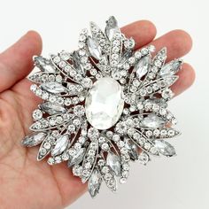 "Stunning large crystal rhinestone brooch rhinestone jewelry embellishment, which can be used for your DIY project -glam wedding, bridal dress sash, bridesmaid dress, wedding cake, ring pillow, event decor, frame and pillow decorations, crafts, scrap booking, jewelry gift and much more. Size: 3 3/4\"H x 3 1/2\"W Stones color: clear rhinestones Metal: Silver plated This big crystal brooch can be ordered with pin in the back to add to wedding gown or dress sash, to wire into brooch bouquet, or any Silver Crystal Pins For Wedding, Silver Crystal Wedding Pins, Wedding Crystal Brooch Pins, Wedding Crystal Pins With Rhinestones, Crystal Wedding Pins, White Crystal Brooch With Rhinestones, Bling Cakes, Argentium Silver Jewelry, Bridal Brooch