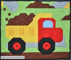 a quilted wall hanging with a construction truck on it