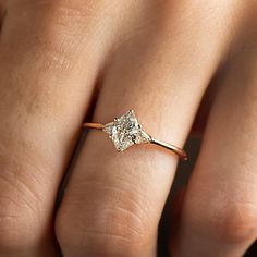 a woman's hand with a diamond ring on top of her finger, showing the center stone