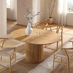 a wooden table with chairs around it and a vase filled with flowers in the middle