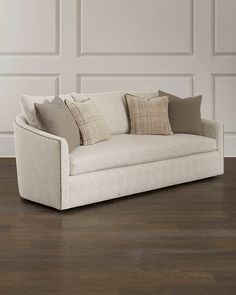 a white couch sitting on top of a hard wood floor