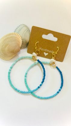 These ocean blue inspired beaded hoops will look great with a maxi dress on your next vacation to the beach!  Beaded Hoops Details:  - handmade  - ombre effect ocean blue seed beads  - white gemstone (howlite) resembling a seashell - hypoallergenic french hooks  *when you buy the whole vacation collection, shipping is free!* Blue Hoop Jewelry For The Beach, Handmade Blue Summer Jewelry, Handmade Summer Blue Jewelry, Bohemian Heishi Beads Jewelry For Summer, Summer Bohemian Heishi Beads Jewelry, Colorful Heishi Beads Beach Jewelry, Turquoise Heishi Beads Jewelry For Vacation, Beaded Hoop Jewelry For Beach, Beaded Hoop Jewelry For The Beach