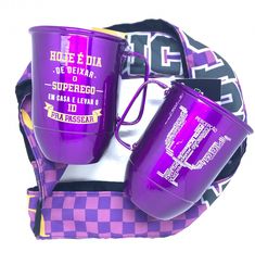 two purple coffee mugs sitting on top of a checkerboard pattern bag with matching straps