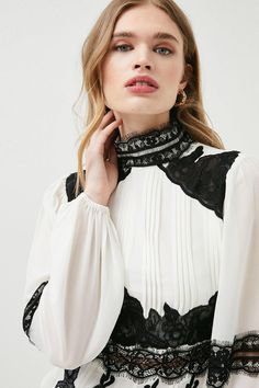 Bringing A Sense Of Opulent Gothic Glamour To High Summer, This Gauzy Woven Blouse Blends Delicate Lace Panels With Crisp Front Presses And Romantic Puff Sleeves. Spin Around To Showcase The Unexpected Back Cut-Out - A Modern Detail That Instantly Revives The Polished, High-Necked Silhouette. Elegant Spring Lace Top With Contrast Lace, Spring Party Lace Top With Contrast Lace, White Elegant Tops With Contrast Lace, Gothic Tops With Lace Trim For Fall, Elegant White Tops With Contrast Lace, Elegant Fall Blouse With Lace Patchwork, Gothic Lace Tops For Fall, Elegant Lace Patchwork Top For Fall, Elegant Fall Lace Patchwork Top