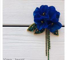 a blue flower with green beads on it