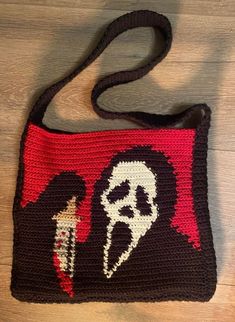 a crocheted bag with an image of a person holding a knife on it