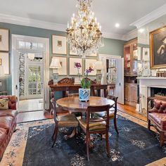 a formal dining room with chandelier, leather chairs, and fireplace in the center