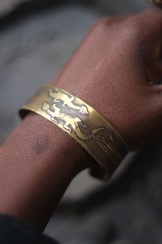 This vintage bracelet with a reptilian motif is unique with etchings one might have found on the walls of a prehistoric cave. Bohemian in mood, the gold-toned  brass piece  will look great layered with other unique jewelry you have collected over the years  condition: it is a little bent. not a real full-curve Adjustable Bracelet With Antique Finish, Unique Adjustable Bracelets With Antique Finish, Unique Adjustable Bracelet With Antique Finish, Etched Brass Bracelet Jewelry, Etched Brass Bracelet, Adjustable Etched Bronze Bracelets, Ceremonial Engraved Brass Cuff Bracelet, Etched Brass Bangle Bracelets, Adjustable Etched Bronze Cuff Bracelet