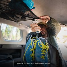 a man is holding something in the back of a car with yellow string attached to it