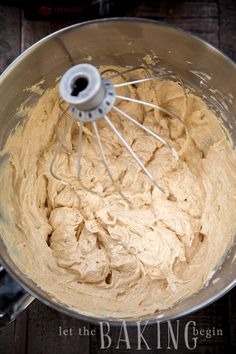 a metal bowl filled with batter on top of a wooden table