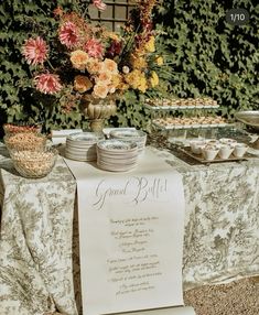 a table topped with plates and bowls filled with food next to a sign that says grand buffet