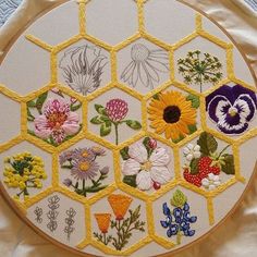 a close up of a embroidery on a piece of cloth with flowers in the center