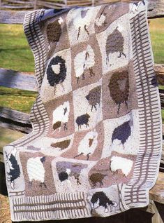 a blanket that has sheep on it sitting on a bench