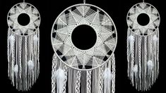 three white dream catchers on a black background