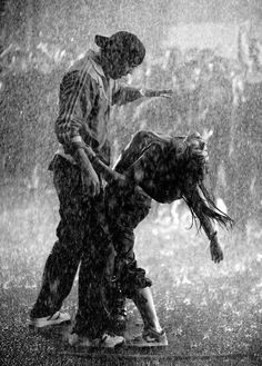 two people are dancing in the rain