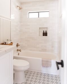 a bathroom with a toilet, tub and sink