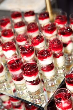 many glasses filled with desserts sitting on top of a table